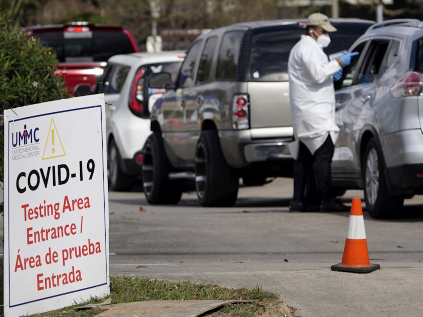 caption: A healthcare worker processes people in line at a United Memorial Medical Center COVID-19 testing site on Nov. 19, in Houston. Texas is rushing thousands of additional medical staff to overworked hospitals as the number of hospitalized COVID-19 patients increases.