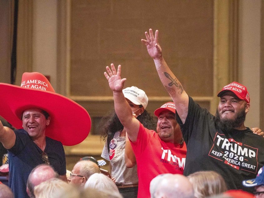 caption: Supporters of President Trump wave during a Latinos for Trump Roundtable at the Arizona Grand Resort in Phoenix on Sept. 14.
