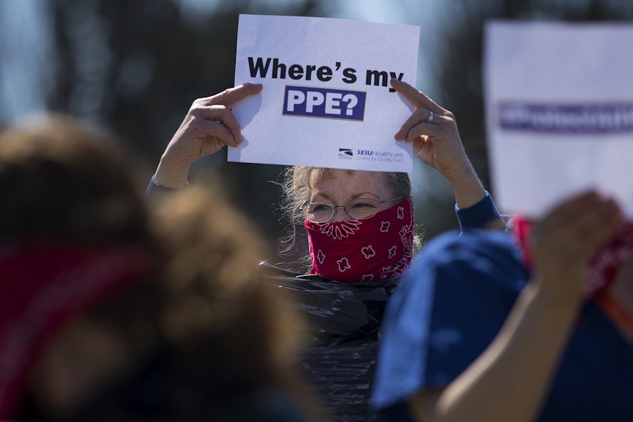 caption: Cindy Hill wears a garbage bag and handkerchief while joining a nationwide protest demanding PPE for healthcare workers on Thursday, April 9, 2020, outside of Evergreen Health in Monroe. 