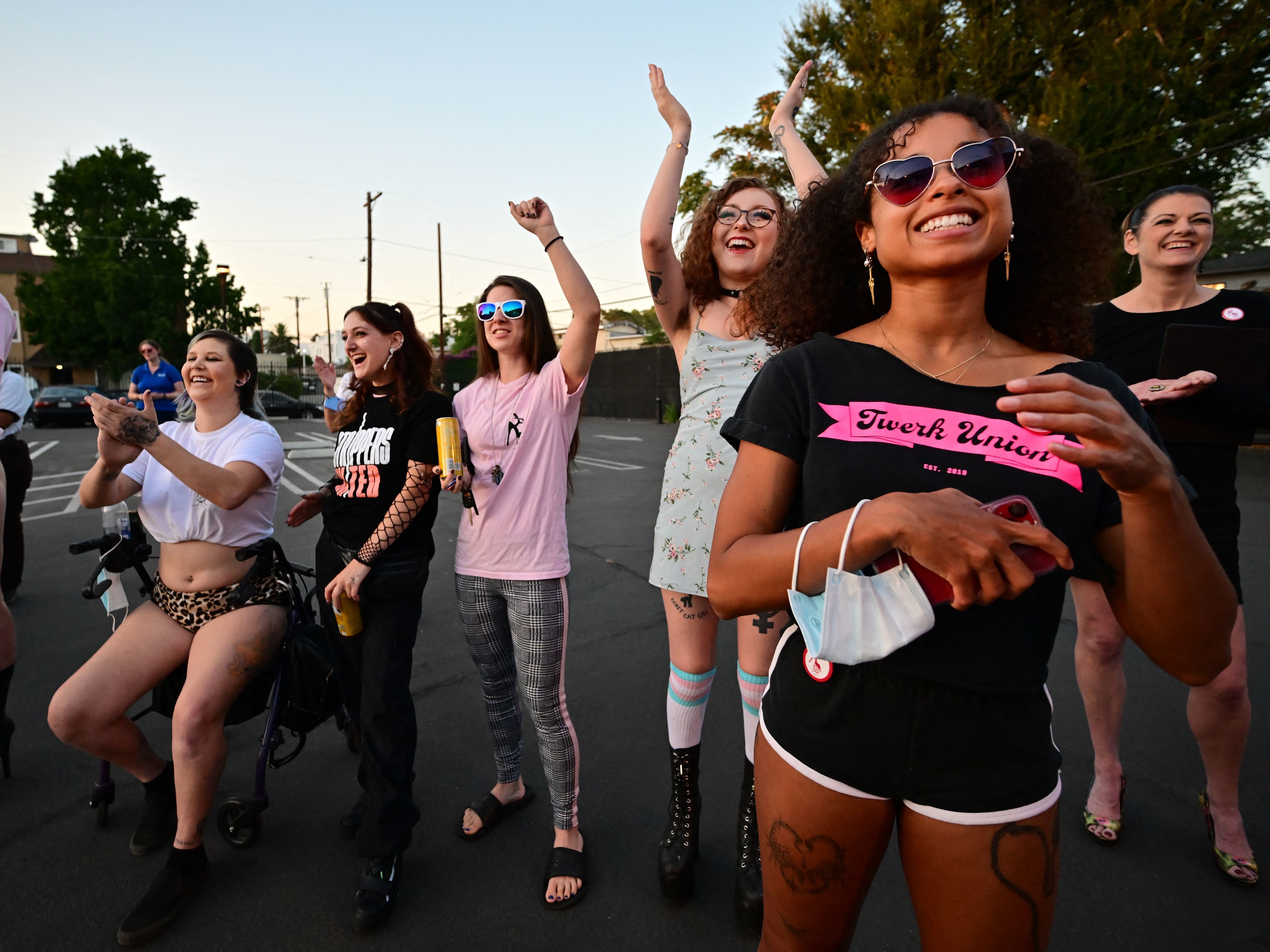 caption: Strippers react to their colleagues addressing the crowd at a rally in support of dancers from the Star Garden Topless Dive Bar in North Hollywood, Calif., in August.