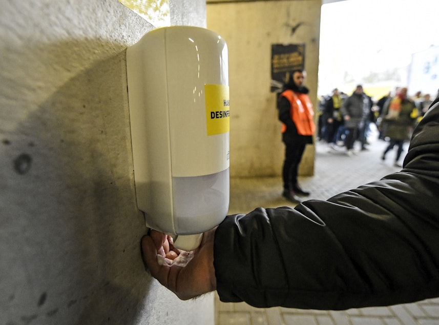 caption: A fan washes his hands at a new disinfection station in the stadium because of the COVID-19 coronavirus outbreak in Germany prior the German Bundesliga soccer match between Borussia Dortmund and SC Freiburg in Dortmund, Germany, Saturday, Feb. 29, 2020. 