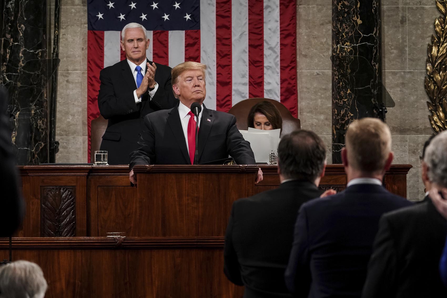 caption: President Donald Trump gives his State of the Union address to a joint session of Congress, Tuesday, Feb. 5, 2019 at the Capitol in Washington, as Vice President Mike Pence, left, and House Speaker Nancy Pelosi look on. (Doug Mills/The New York Times via AP, Pool)