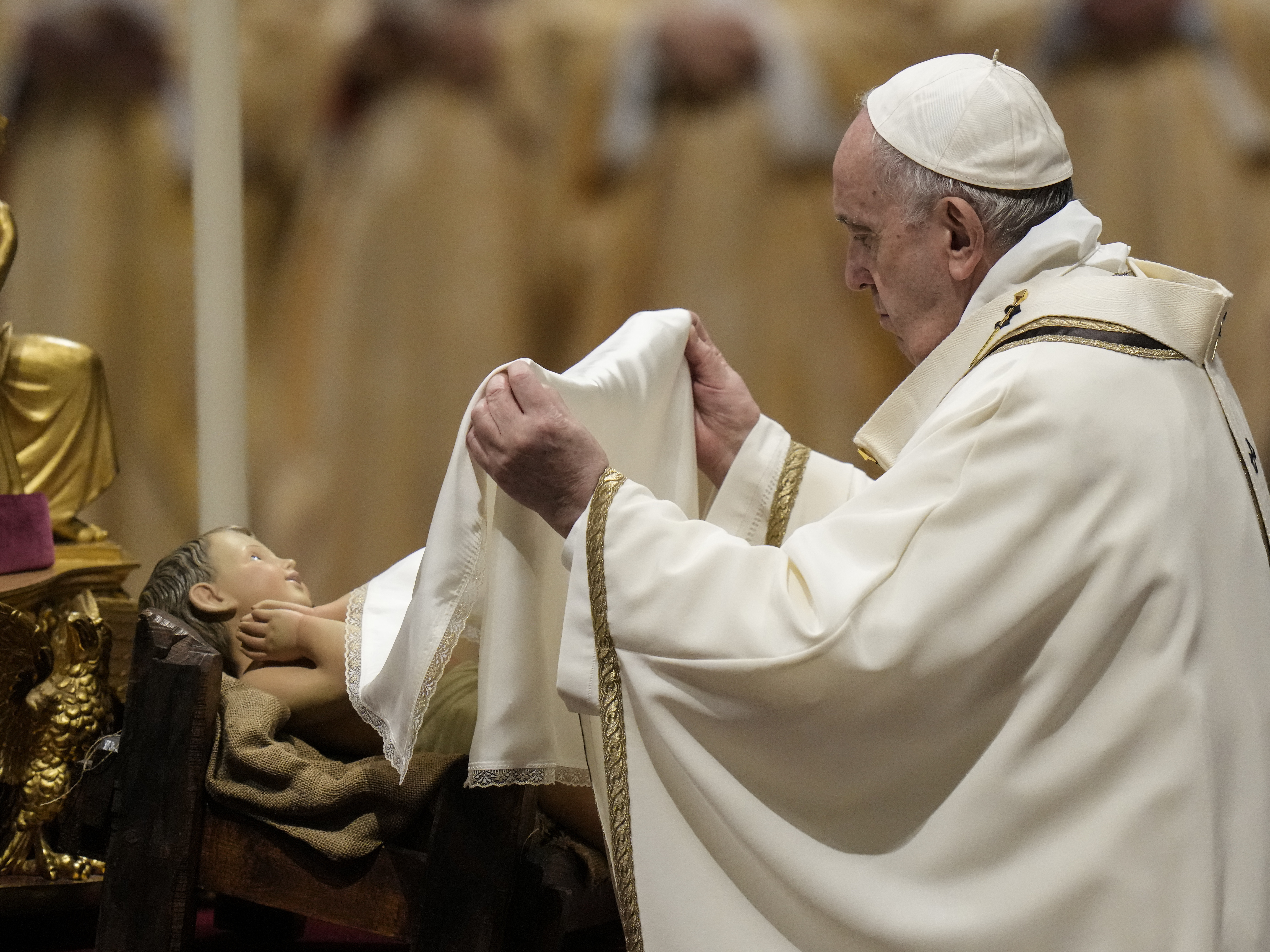 caption: Pope Francis unveils a statue of Baby Jesus as he celebrates Christmas Eve Mass at St. Peter's Basilica, at the Vatican, on Friday.