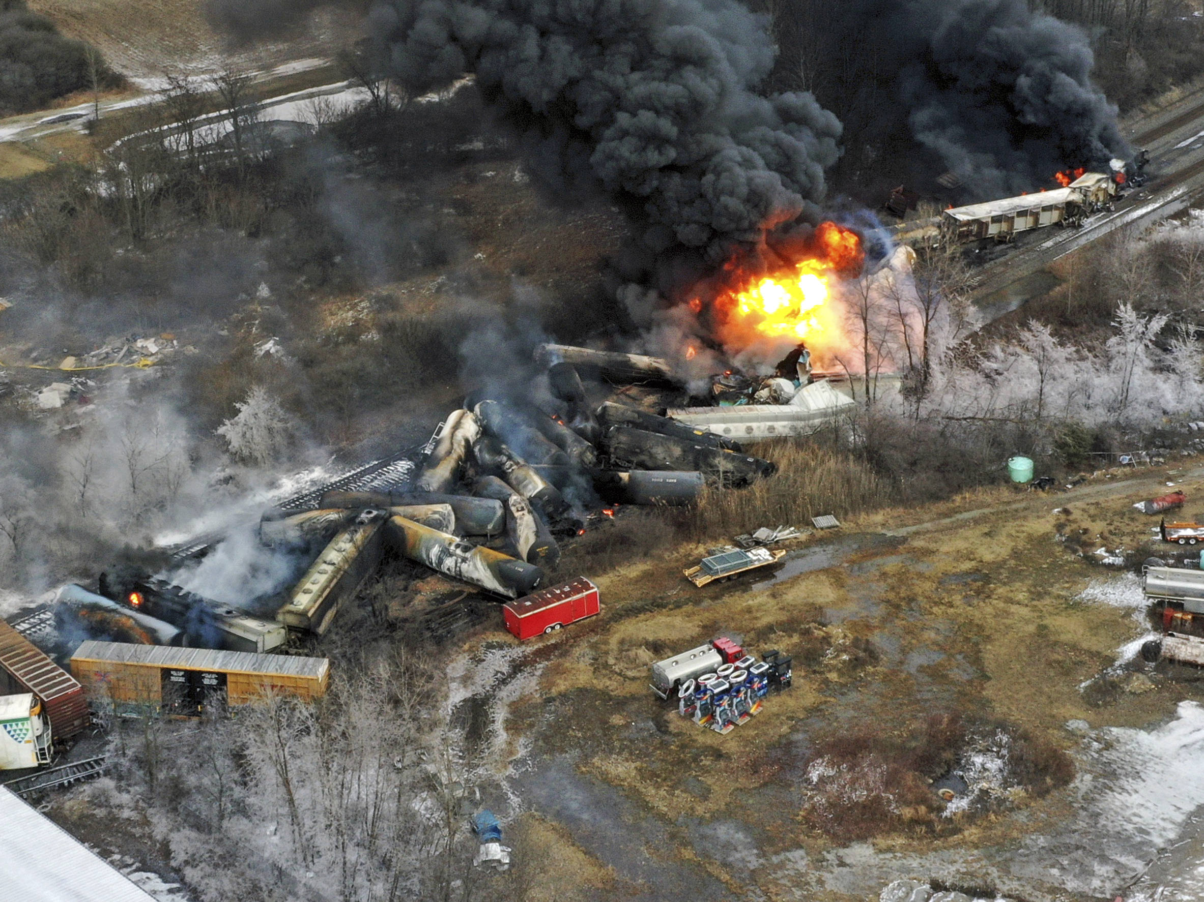 caption: Portions of a Norfolk Southern freight train that derailed in East Palestine, Ohio on Feb. 3 remained on fire the next day.