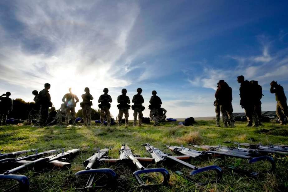 caption: Weapons lie on the ground as Ukrainian personnel take a break during training at a military base with UK Armed Forces in Southern England, Wednesday, Oct. 12, 2022. 