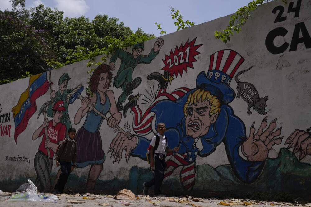 caption: Children pass by a mural depicting Uncle Sam in Caracas, Venezuela, Wednesday, May 18, 2022. (Ariana Cubillos/AP)