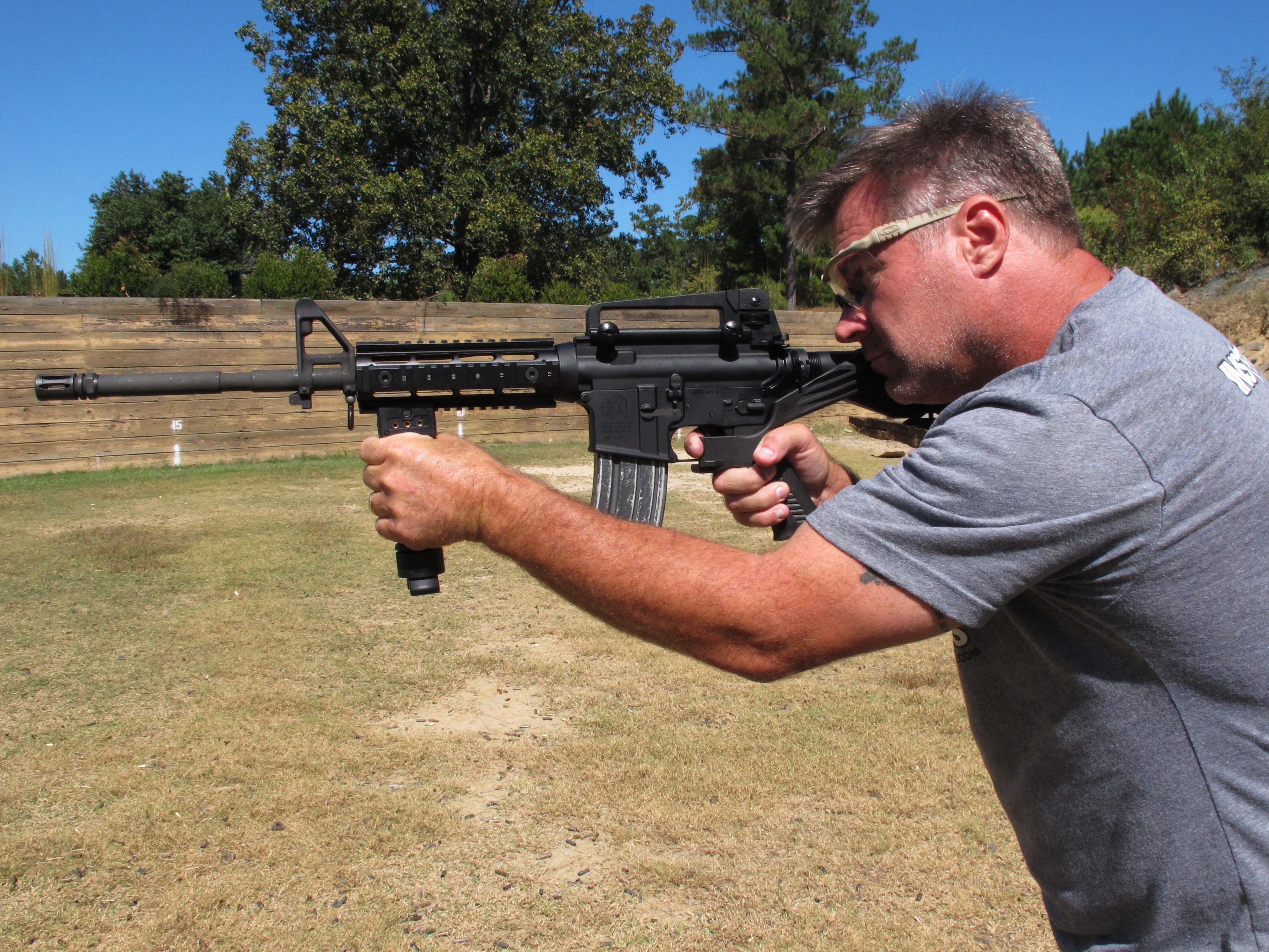 caption: Shooting instructor Frankie McRae aims an AR-15 rifle fitted with a "bump stock" that allows the semi-automatic to shoot as fast as an illegal machine gun. As of March 26, bump stocks will be illegal unless a court puts an injunction on the federal ban.