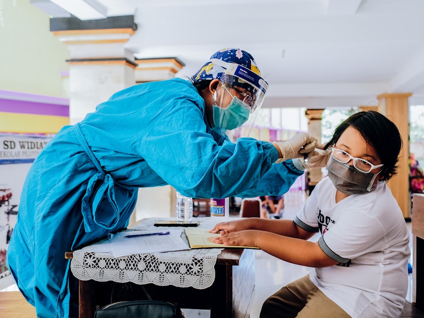 caption: Vaccines for measles-rubella and cervical cancer are administered at a school in Jimbaran, Indonesia. Vaccination rates have dropped during the pandemic.