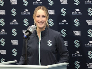 caption: Seattle Kraken new assistant coach Jessica Campbell speaks during an NHL hockey press conference Wednesday in Seattle. Campbell will become the first woman to work on the bench of an NHL franchise after the team hired her as an assistant coach.