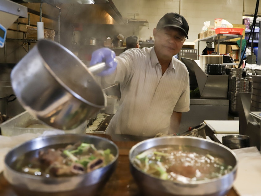 caption: A cook at Pho Bac Súp Shop serving the broth. Owners Quynh-Vy and Yenvy Pham were nominated for "Outstanding Restaurateur" in the 2024 James Beard Awards.