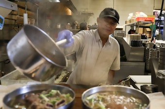 caption: A cook at Pho Bac Súp Shop serving the broth. Owners Quynh-Vy and Yenvy Pham were nominated for "Outstanding Restaurateur" in the 2024 James Beard Awards.