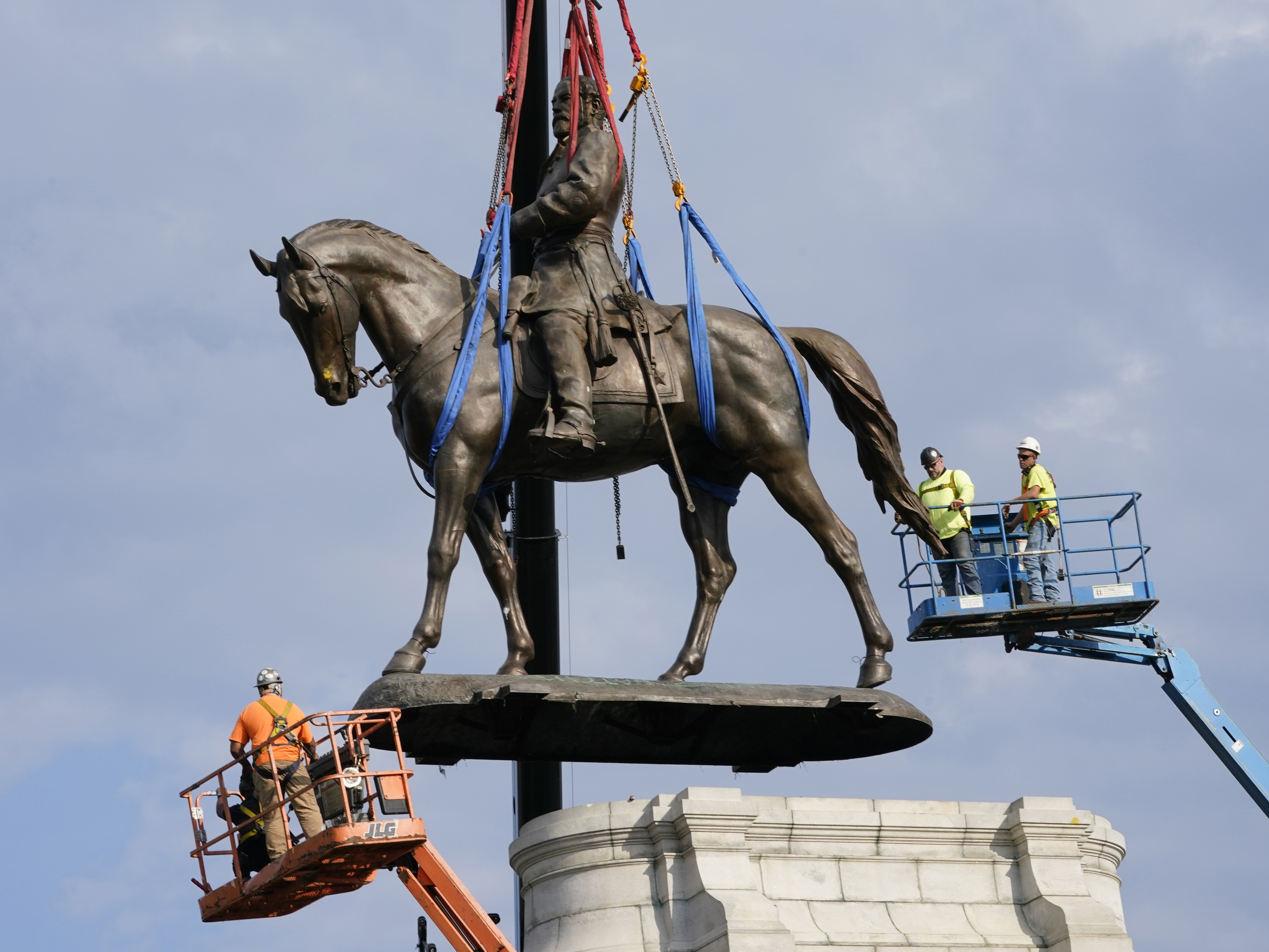 caption: Crews remove the statue of Robert E. Lee in Richmond on Sept. 8. Pending city council approval, the statue and eight other Confederate monuments will be moved to Richmond's Black History Museum.