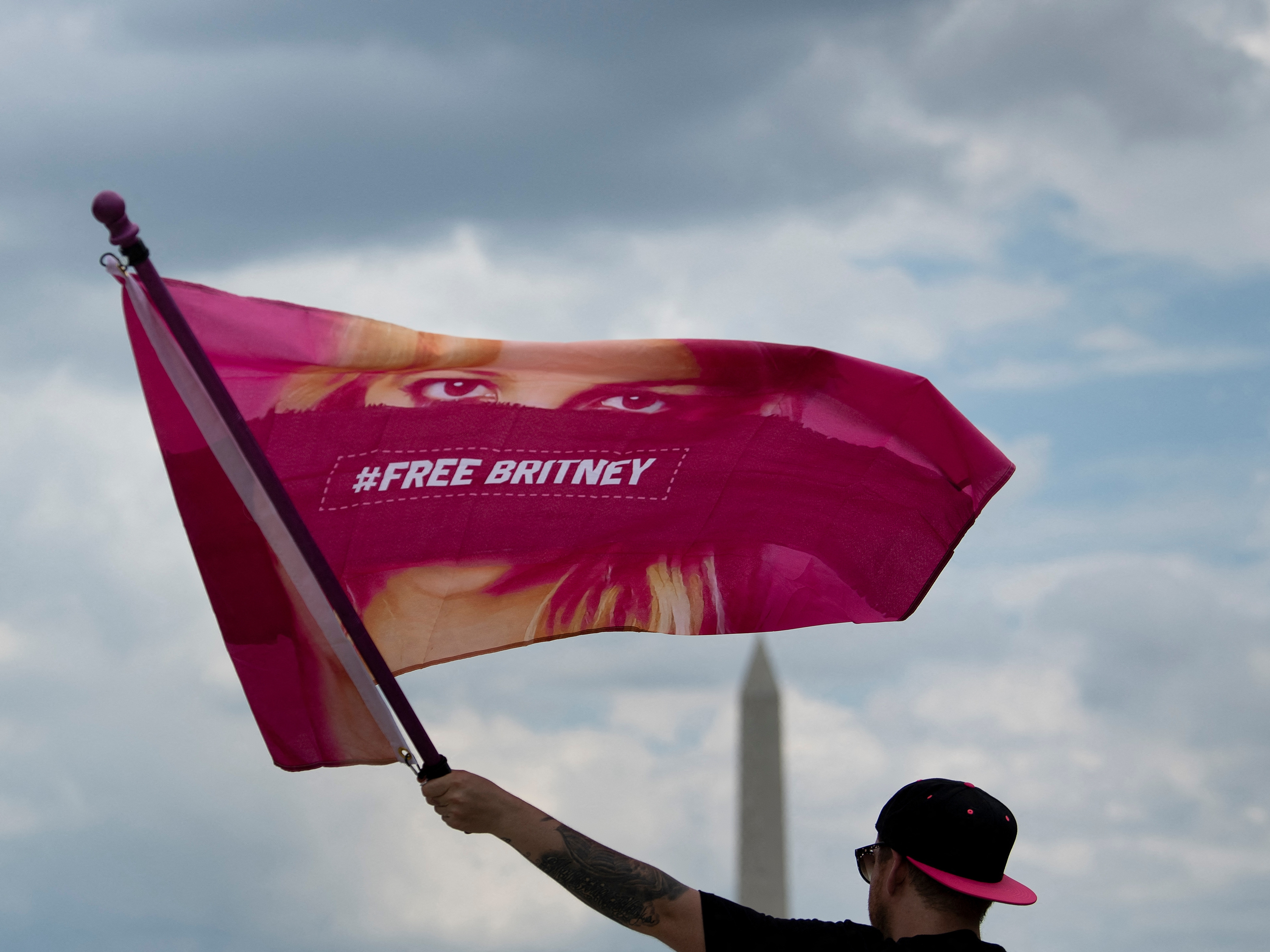 caption: A man waves a "Free Britney" flag during a rally in front of the Lincoln Memorial in Washington, D.C. protesting the conservatorship of Britney Spears July 14, 2021.