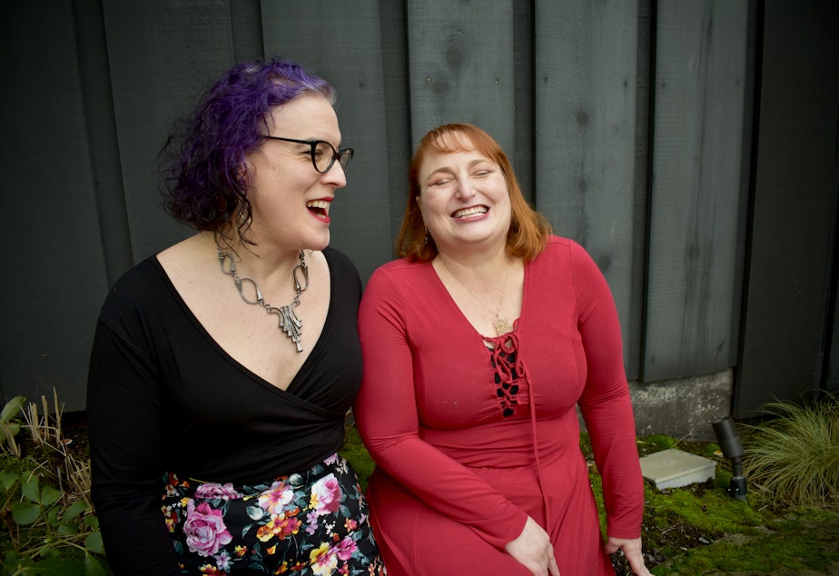 caption: Ex-spouses Maura Hubbell (left) and Lisa Jaffe laugh together in front of Canlis restaurant in Seattle. January 16, 2021. 