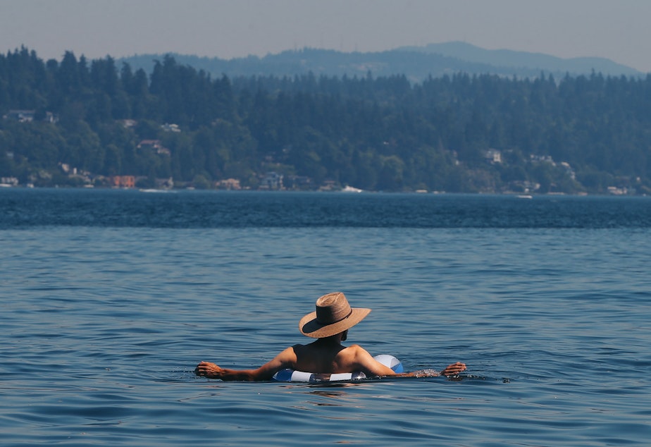 caption: A man floats in Lake Washington at Colman Beach, Monday, June 28. The National Weather Service recorded 108 degrees in SeaTac on Monday, setting an all-time record for the area.