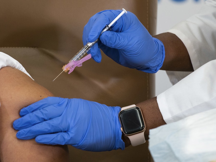 caption: Arlene Ramirez receives the Moderna coronavirus COVID-19 vaccine at Northwell Health's Long Island Jewish Valley Stream hospital in New York City on Dec. 21. Healthcare workers across the country have started receiving COVID-19 vaccines, but doctors and nurses at some hospitals say vaccine distribution has been chaotic.