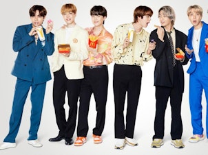 caption: K-Pop group BTS poses with their McDonald's meal.