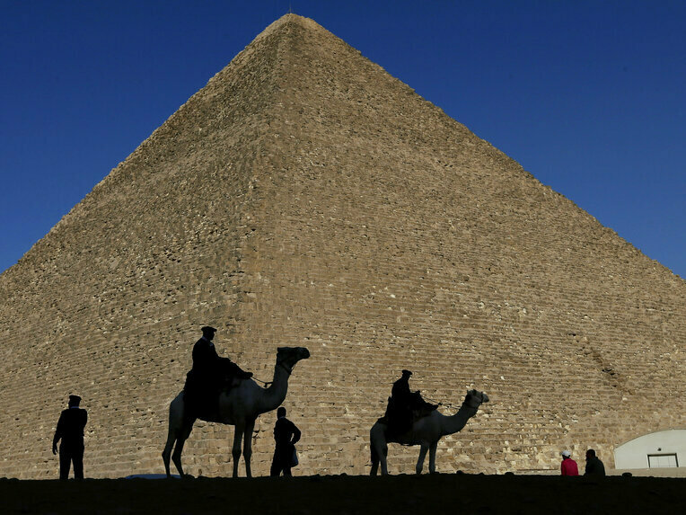 caption: Policemen are silhouetted against the Great Pyramid in Giza, Egypt, in 2012.