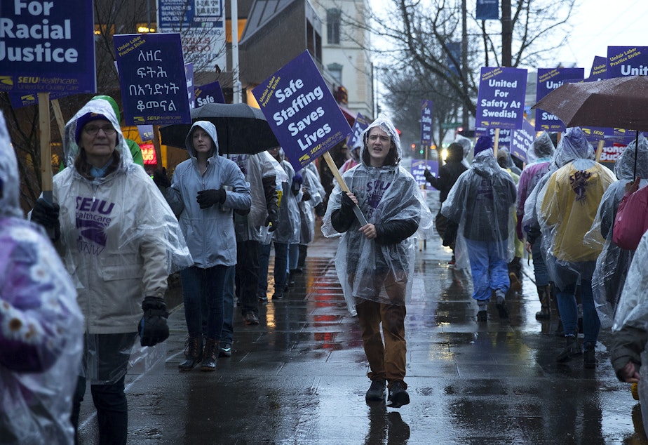 caption: Donavan Pepin, 22, an organizer with SEIU, leads a chant as nurses and caregivers strike on Tuesday, January 28, 2019, outside of the Swedish Ballard Campus along NW Market Street in Seattle.