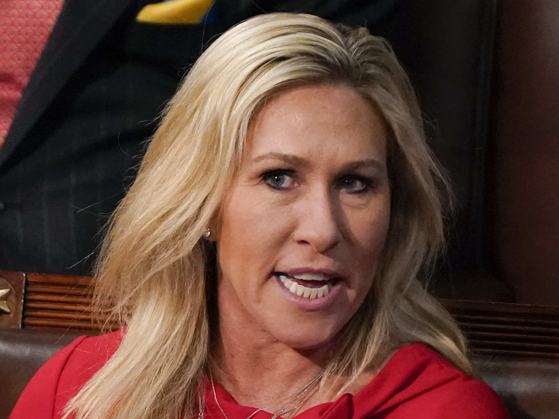 caption: Rep. Marjorie Taylor Greene, R-Ga., talks as President Joe Biden delivers his first State of the Union address to a joint session of Congress, at the Capitol in Washington on March 1, 2022.