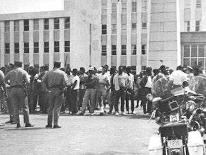 caption: Protestors held a rally at a municipal building prior to the riot in Augusta, Ga., in 1970. Approximately 300 people attended and 25–30 police officers stood watch.