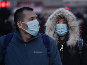 caption: Chinese travelers at a railway station in Beijing, China, wear face masks to protect themselves from the new coronavirus on Jan. 21, 2020. The virus was first identified in Wuhan, China, in Dec. 2019, and since then has quickly spread worldwide.