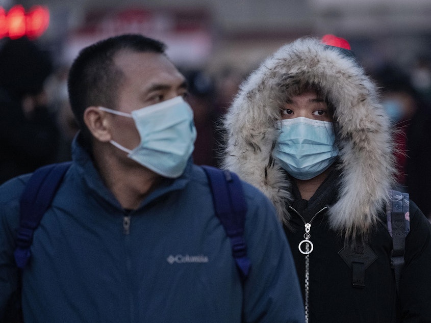 caption: Chinese travelers at a railway station in Beijing, China, wear face masks to protect themselves from the new coronavirus on Jan. 21, 2020. The virus was first identified in Wuhan, China, in Dec. 2019, and since then has quickly spread worldwide.