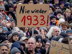 caption: People gather as they protest against the AfD party and right-wing extremism in Frankfurt/Main, Germany, Saturday, Jan. 20, 2024. Sign reads "never again 1933".