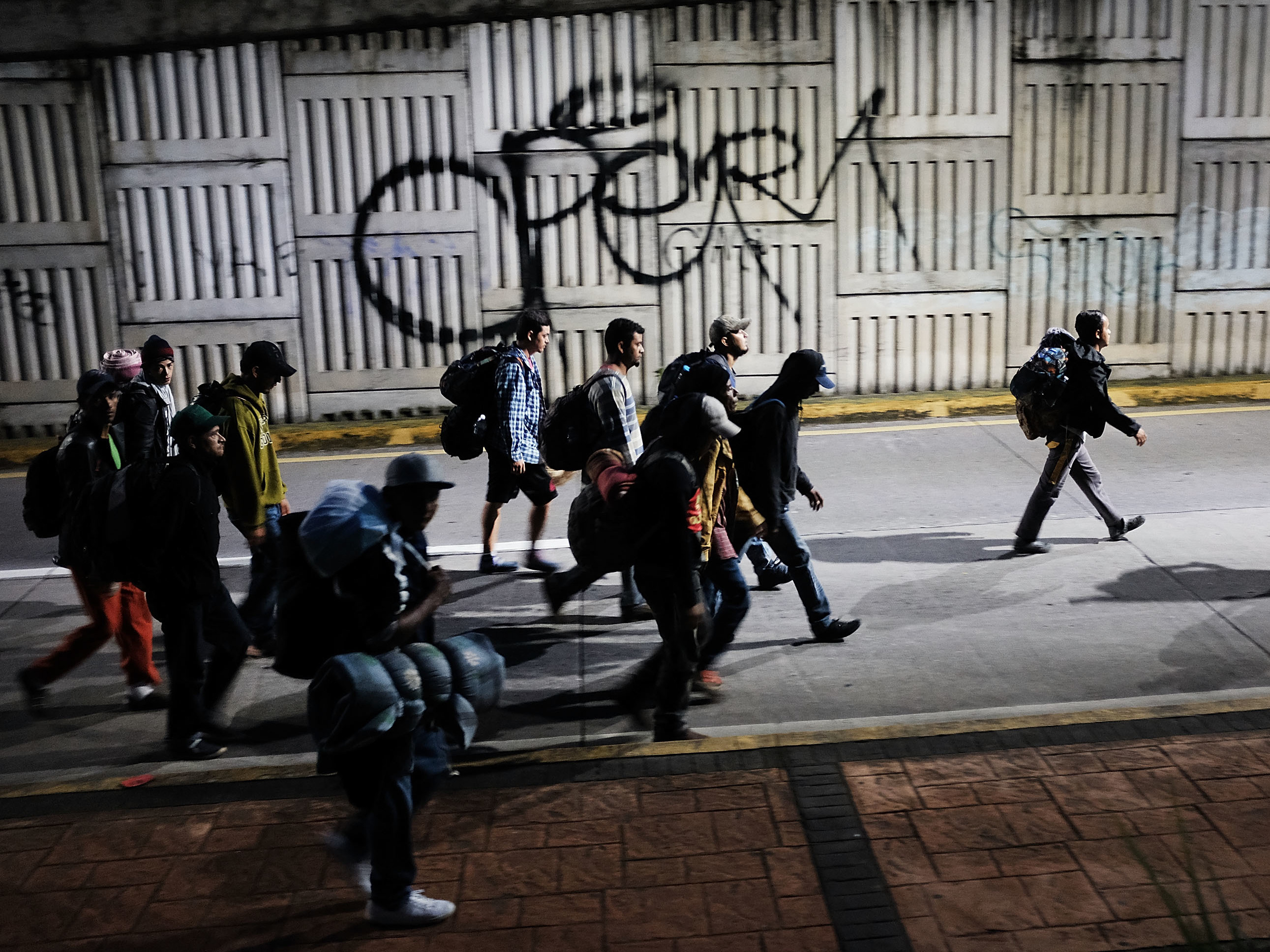 caption: Hundreds of Central American migrants move in the early morning hours toward their next destination of Puebla on Monday in Cordoba, Mexico. The Trump administration issued a new rule for asylum-seekers on Thursday.