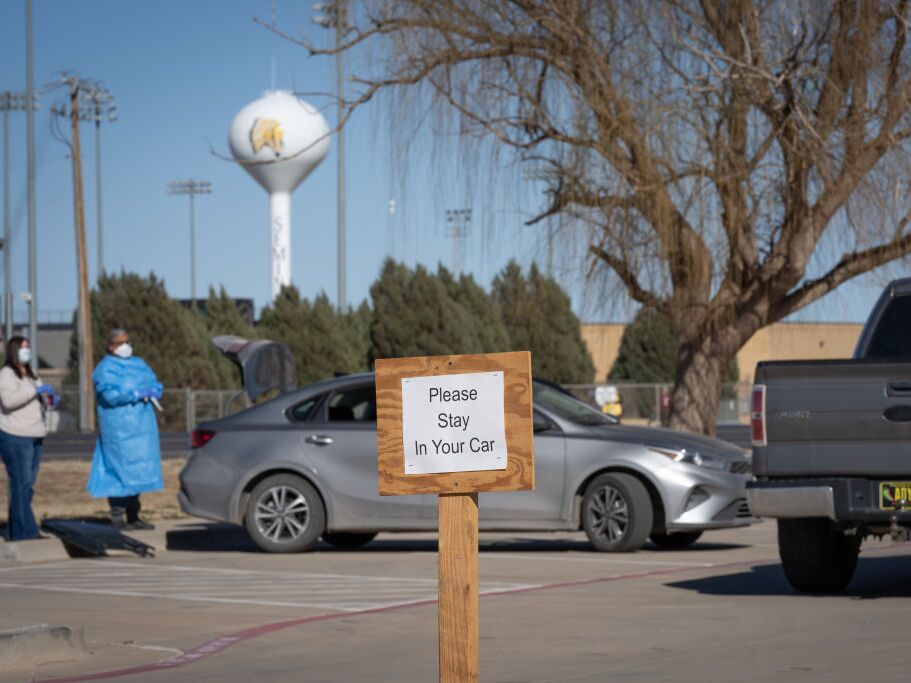caption: Signs point the way to measles testing in the parking lot of the Seminole Hospital District across from Wigwam Stadium on February 27, 2025 in Seminole, Texas.