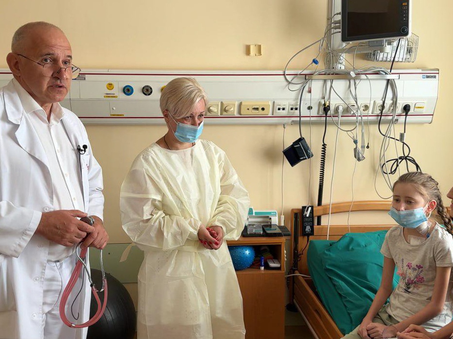 caption: Dr. Boris Todurov, left, performed heart transplant surgery on his patient, 12-year-old Kira Skilarova, second from right, during a Russian attack on Kyiv on July 9.  Kira received her heart from a 4-year-ld girl who died earlier that evening at a hospital across the city. Also pictured are the heart donor's mother,  second from left, and Kira's mom, far right.