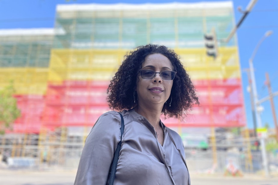 caption: Sophia Benalfew, director of the group Ethiopian Communities of Seattle, stands in front of the almost complete Ethiopian Village project in summer of 2022