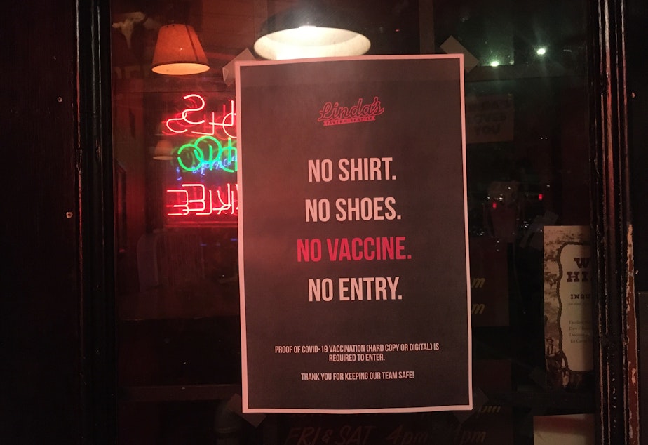 caption:  A sign outside Linda's Tavern in Seattle in late July 2021 asks customers for proof of vaccination against COVID-19.
