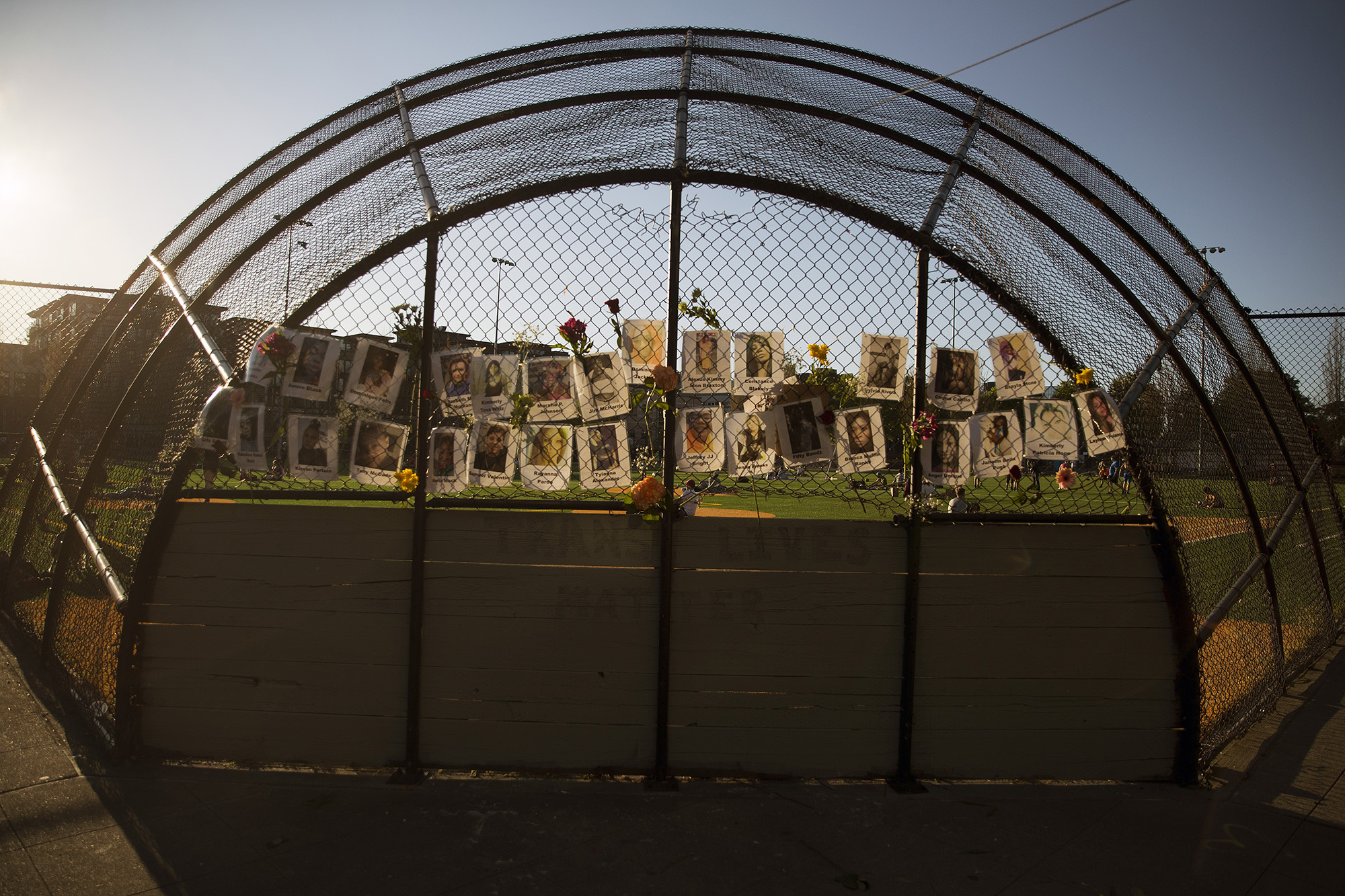 caption: Photographs and flowers remain following a Trans Lives Matter vigil, shown here after the reading of the guilty verdict in the trial of Derek Chauvin for the murder of George Floyd, on Tuesday, April 20, 2021, at Cal Anderson Park in Seattle. 