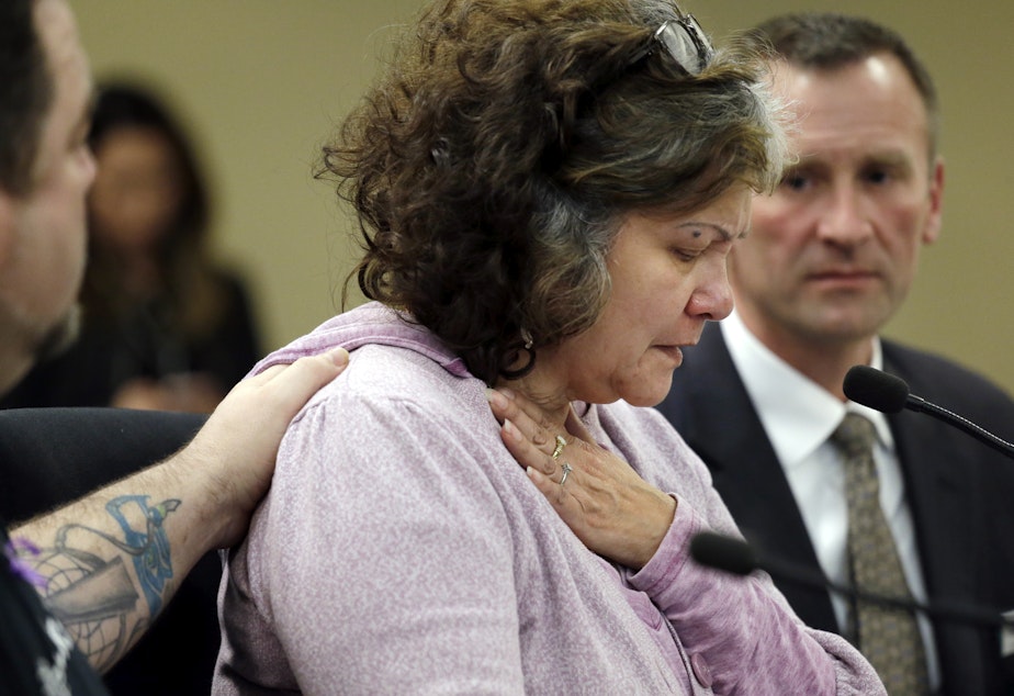 caption: Marilyn Covarrubias, center, is comforted as she begins to cry while testifying about the shooting death in 2015 of her son by police, at a House Public Safety Committee hearing on Jan. 31, 2017, in Olympia, Wash.