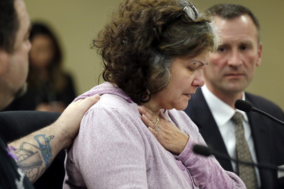 caption: Marilyn Covarrubias, center, is comforted as she begins to cry while testifying about the shooting death in 2015 of her son by police, at a House Public Safety Committee hearing on Jan. 31, 2017, in Olympia, Wash.