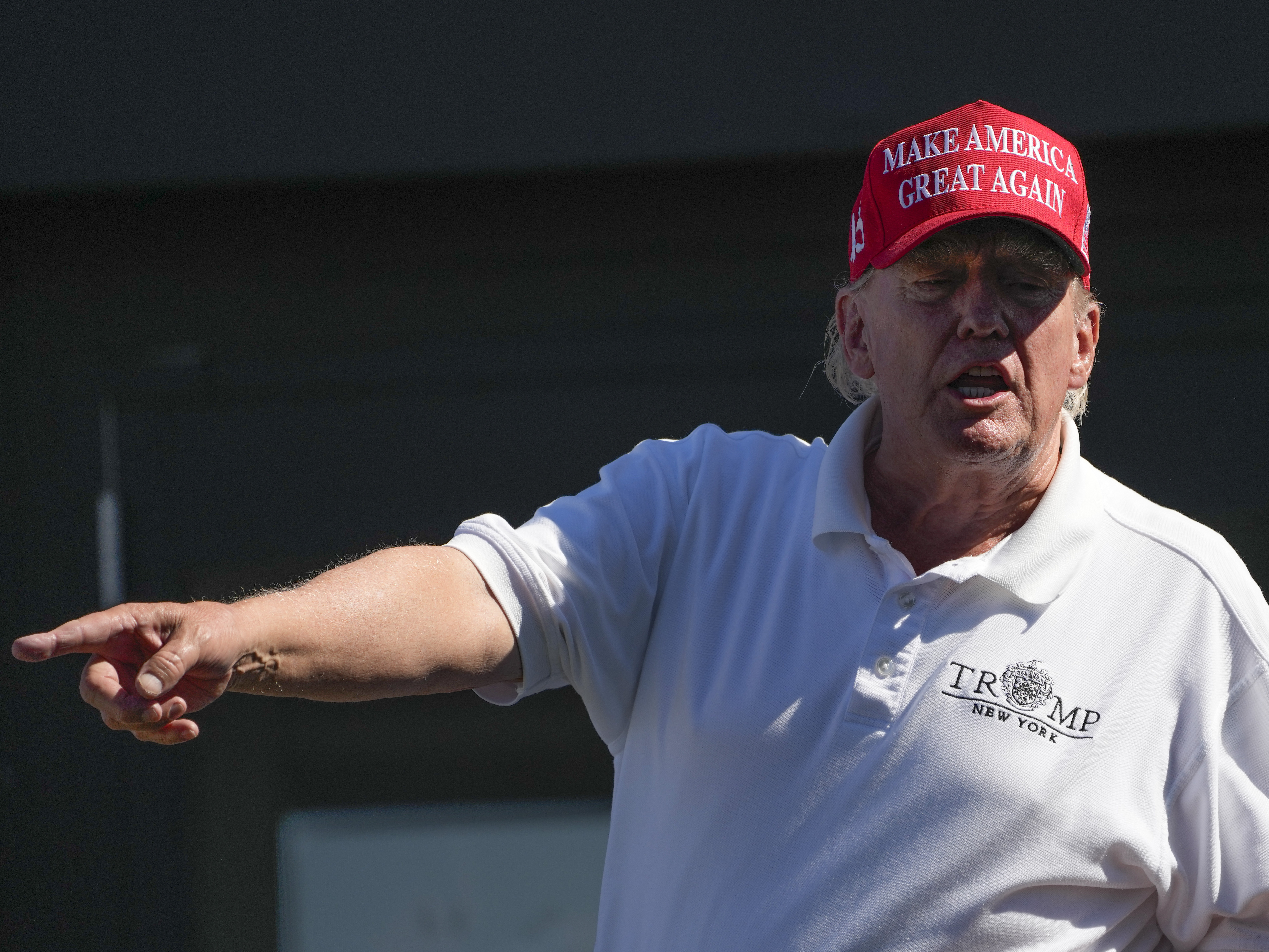 caption: Former President Donald Trump talks to people in the crowd during the final round of the Bedminster Invitational LIV Golf tournament in Bedminster, N.J., Sunday, Aug. 13, 2023.