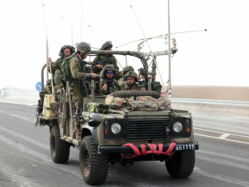 caption: Israeli soldiers patrol a road close to the border with Gaza on Sunday.