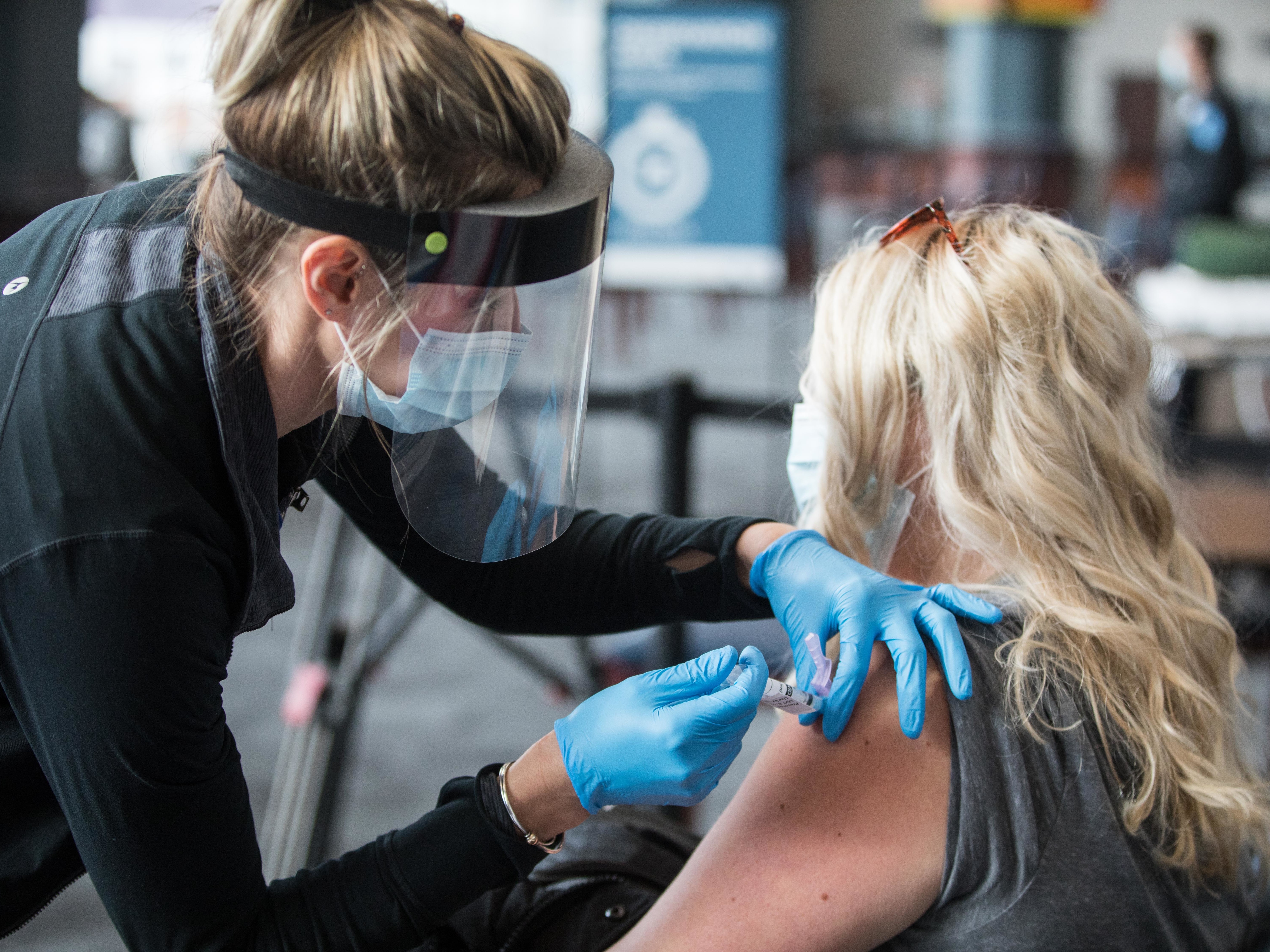 caption: A woman receives the COVID-19 vaccine last week at Gillette Stadium in Foxborough, Mass. Setting up community vaccination centers will be a key to getting the vaccine to millions, an adviser to President Biden says.