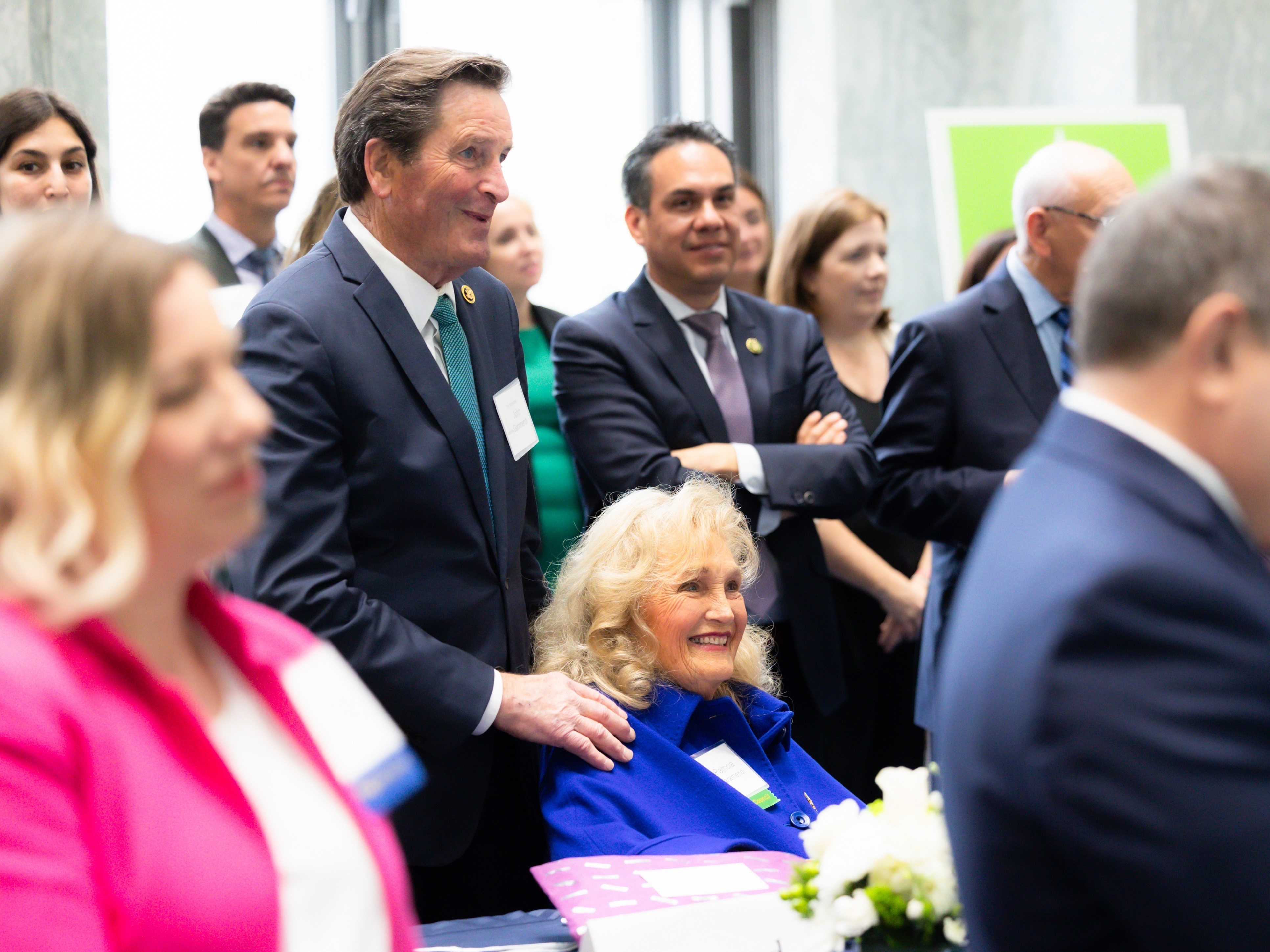 caption: Patti Garamendi (seated in blue) chairs the congressional spouses club. She recently attended a Capitol Hill reception with her husband, Rep. John Garamendi, D-Calif. (standing above her) to tout a bipartisan project aimed at cancer prevention.