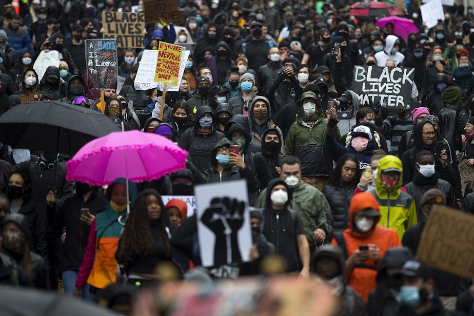 caption: Thousands march on James Street while protesting the police killing of George Floyd, on Saturday, May 30, 2020, in Seattle.