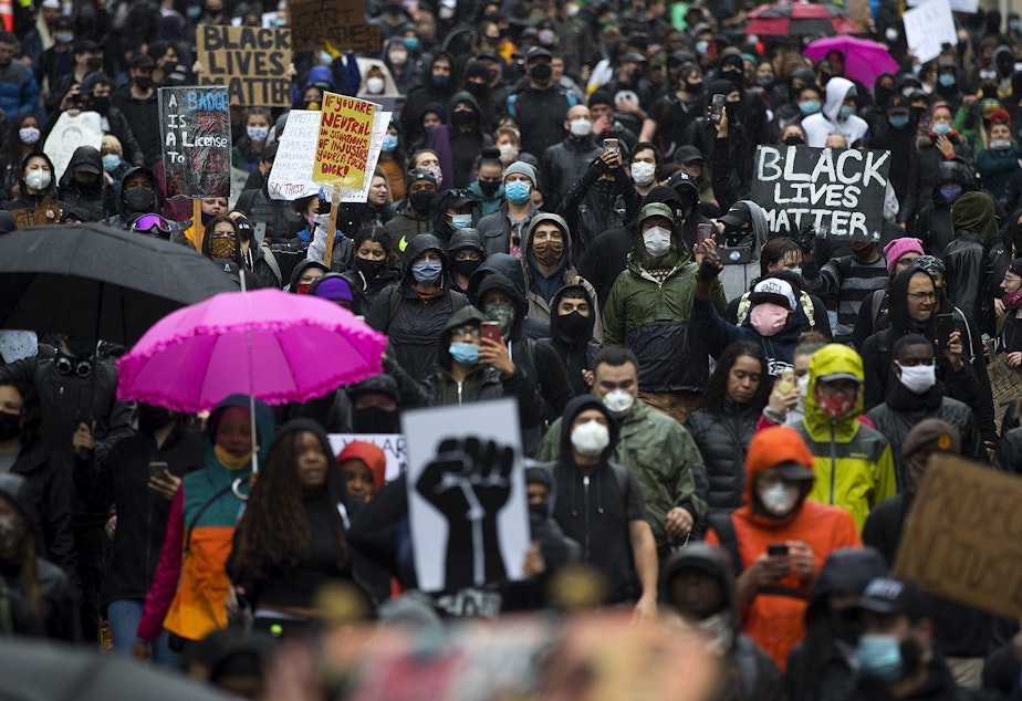 caption: Thousands march on James Street while protesting the police killing of George Floyd, on Saturday, May 30, 2020, in Seattle.