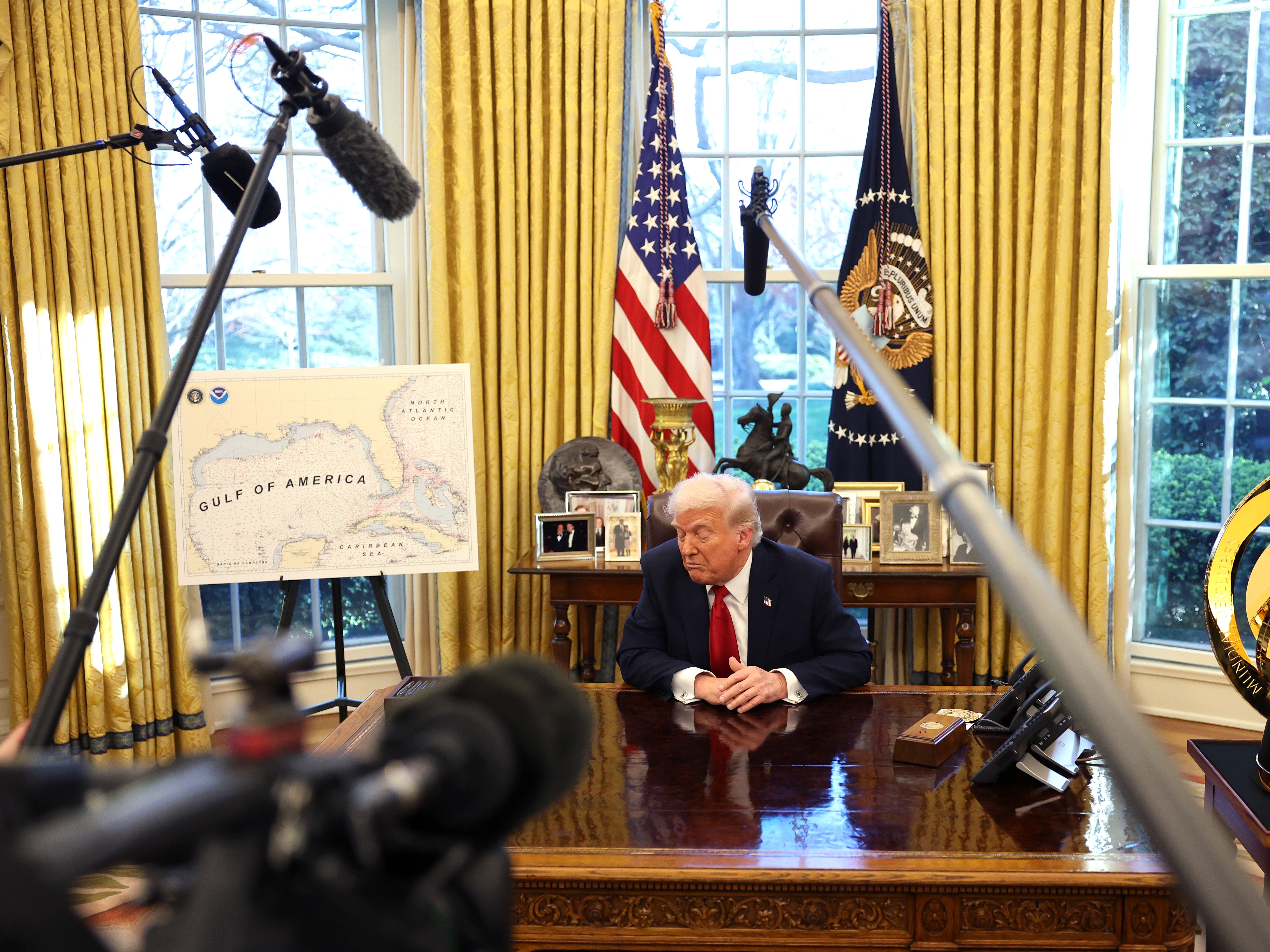 caption: President Trump speaks to the press in the Oval Office next to a map of what he has renamed the "Gulf of America" on March 26. The administration has denied the Associated Press access to such events because it calls the body of water the "Gulf of Mexico," even as it acknowledges his preferred designation.
