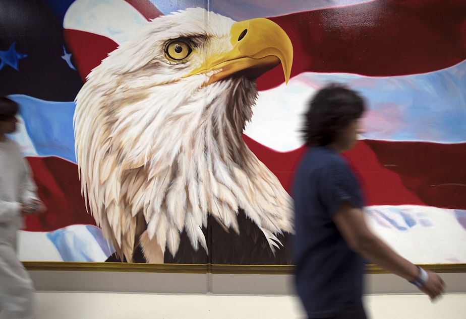 caption: Dozens of murals hang on the walls at the Northwest Detention Center. They're painted by detainees.