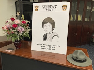 caption: A poster of Marise Ann Chiverella is displayed with a vase of flowers and a trooper's hat at a Pennsylvania State Police news conference in Hazleton, Pa., Thursday.