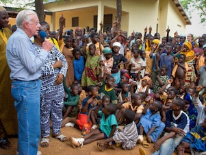 caption: On a 2007 visit to Savelugu Hospital in Ghana, President Jimmy Carter asks a group of children if they've had Guinea worm. A raised hand is a yes.