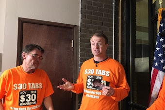 caption: Professional initiative sponsor Tim Eyman holds a photograph from his first successful $30 car tabs initiative in 1999.