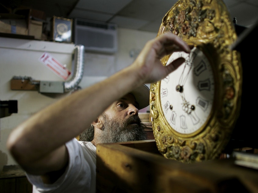 caption: Mark Brown repairs a clock at Brown's Old Time Clock Shop in Plantation, Florida in 2007.