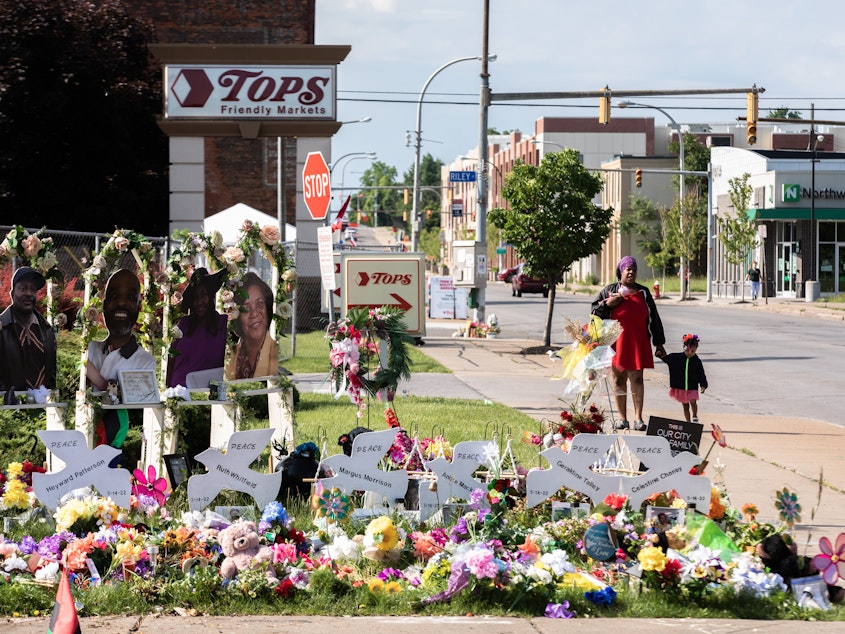 caption: A memorial to the 10 victims of the racist shooting at a Tops grocery store in Buffalo. Two tech companies must face a lawsuit alleging that their algorithms played a role in radicalizing the shooter, a judge ruled Monday.