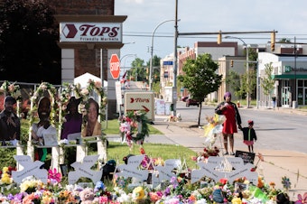caption: A memorial to the 10 victims of the racist shooting at a Tops grocery store in Buffalo. Two tech companies must face a lawsuit alleging that their algorithms played a role in radicalizing the shooter, a judge ruled Monday.